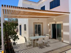 a patio with a table and chairs on a deck at Sol y Mar Malama Villa in Paralimni