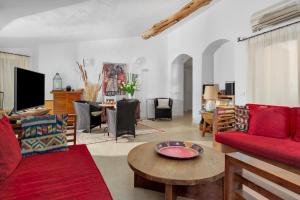 sala de estar con sofá rojo y mesa en Private Villa ORIONE, en Porto Cervo