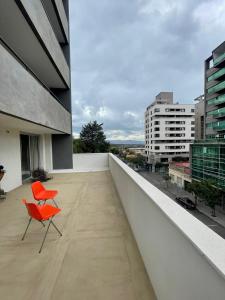 a balcony with two orange chairs on a building at Amplio departamento céntrico Plaza Belgrano in San Salvador de Jujuy