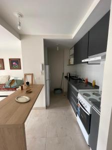 a kitchen with black cabinets and a counter top at Amplio departamento céntrico Plaza Belgrano in San Salvador de Jujuy