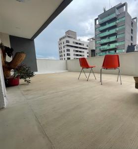 two red chairs sitting on top of a roof at Amplio departamento céntrico Plaza Belgrano in San Salvador de Jujuy