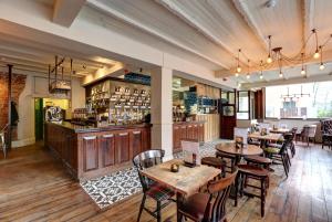 a restaurant with tables and chairs and a bar at PubLove @ The Exmouth Arms, Euston in London
