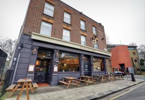 a building with tables and benches in front of it at PubLove @ The Exmouth Arms, Euston in London
