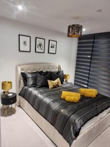 a bedroom with a large bed with yellow pillows at Stunning Sea View Two Bed Two Bathroom Apartment in Porthcawl