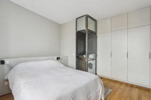 a white bedroom with a bed and white cabinets at Le Saint Charles - Versailles in Versailles