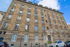 a large brick building with cars parked in front of it at Le Saint Charles - Versailles in Versailles