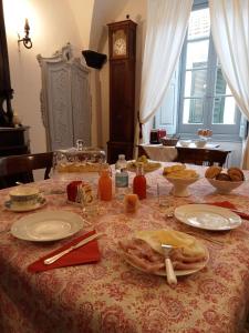 a table with plates of food on it with a clock at Bed & Breakfast Scià Dina in Toirano