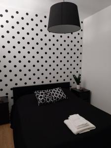 ナポリにあるMolo 33 Napoliのベッドルーム1室(黒いベッド1台、水玉の壁付)