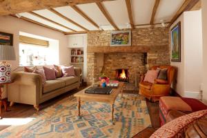 a living room with a couch and a fireplace at The Crown Inn, Church Enstone in Chipping Norton