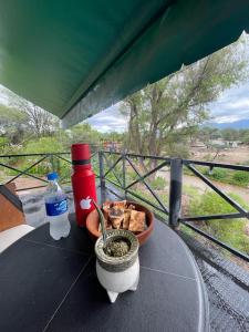 uma mesa com uma tigela de comida e uma garrafa de água em CABAÑAS VILLA HUACO em El Huaco