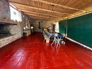 Pokój z czerwoną podłogą i stołem w obiekcie CABAÑAS VILLA HUACO w mieście El Huaco