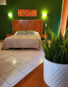 a bedroom with a bed and a potted plant at Hotel Federico II in Castiglione di Sicilia
