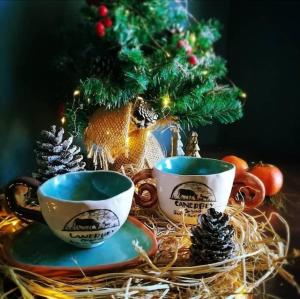 due tazze di caffè su un tavolo con un albero di Natale di Çiftlik ve Dağ evi Kemer - Canerbey a Kemer