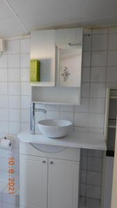 a white bathroom with a sink and a mirror at la garrigue in Villeneuve-lès-Avignon