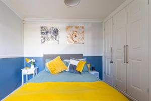a bedroom with a bed with blue and yellow at West Hill Stays Chapel Alleton LS7 - 3 bed Sleeps 5 - close to City Center - free parking - contractor welcome in Moortown