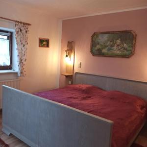 1 dormitorio con 1 cama grande con manta roja en Zum Froschteich, en Damnatz