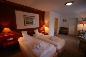 a hotel room with two beds with towels on them at Park Hotel am Schloss in Ettringen +20 photos