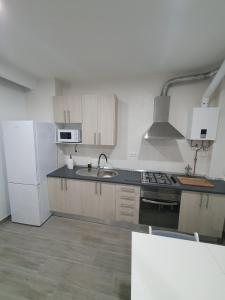 a kitchen with a sink and a stove and a refrigerator at Melania House in Candeleda