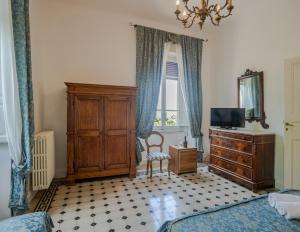 a bedroom with a bed and a dresser and a tv at Villa Le Querciolaie in Monteverdi Marittimo