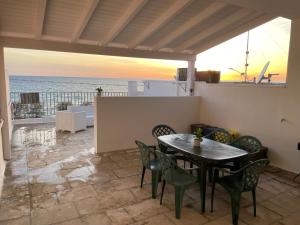 un patio con tavolo, sedie e vista sull'oceano di Appartamenti Antonaci 2 a Gallipoli