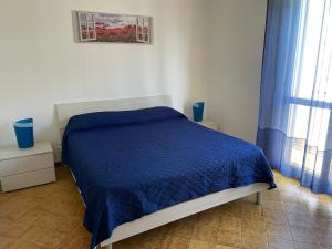 una camera con un letto e una coperta blu di Appartamenti Antonaci 2 a Gallipoli