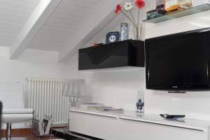 a living room with a television on a white wall at Casa Marcone in Deiva Marina
