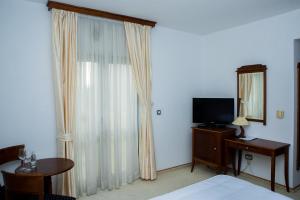 a bedroom with a bed and a mirror and a television at Hotel Hum in Ljubuški