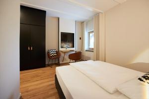 a bedroom with a bed and a desk with a chair at Hotel-Landgasthof KREUZ in Bad Waldsee