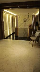 a room with a couch and a chair and a wall at Vip House Résidence in Sousse
