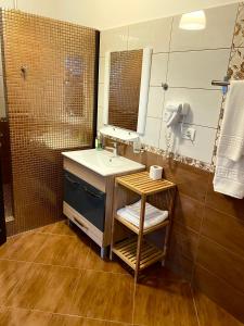 Pensiunea Rix Rooms في فوكشاني: حمام مع حوض ومرآة