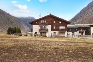 un grand bâtiment au milieu d'un champ dans l'établissement Chalet La Marinella Rododendro, à Livigno