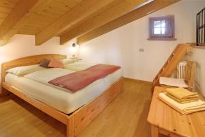 - une chambre avec un grand lit et du parquet dans l'établissement Chalet La Marinella Rododendro, à Livigno