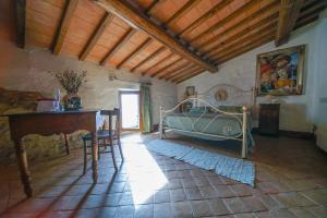 um quarto com uma cama e uma mesa num quarto em Agriturismo La Colombella em Bagni San Filippo