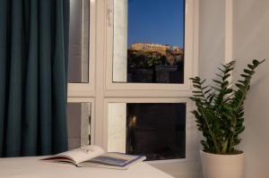 a book sitting on a table in front of a window at Dion Luxury Suites in Athens