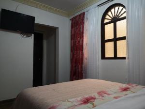 a bedroom with a bed and a window at Hotel Lili - Popayán in Popayan