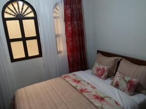 1 cama con 2 almohadas y una ventana en una habitación en Hotel Lili - Popayán, en Popayán