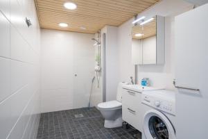 a bathroom with a toilet and a washing machine at Hiisi Homes Kirkkonummi Laajakallio in Kirkkonummi +91 photos