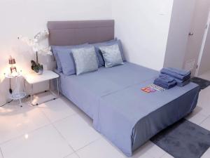 a bedroom with a blue bed with a side table at Elize Wind Residences in Tagaytay