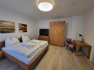 Dormitorio con cama, escritorio y TV en Heine`s Hof, en Oschersleben
