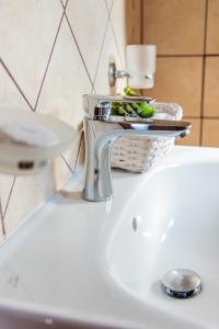un lavabo con grifo y una cesta de verduras en Villa Cavo d' Oro, en Korissia