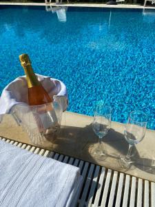 a bottle of champagne and two glasses next to a swimming pool at Villa Paradiso in Latiano