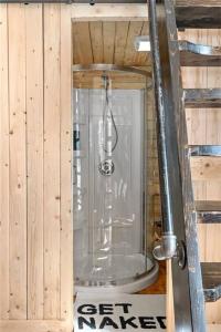 Habitación de madera con baño con ducha. en Cozy Cabin for Intimate Wilderness Escape en Bathurst