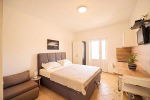 a bedroom with a bed and a couch and a desk at Apartments Marina in Petrcane