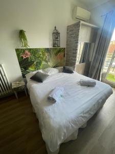 ein Schlafzimmer mit einem großen Bett mit weißer Bettwäsche und Kissen in der Unterkunft Studio Bel Air FSHH in Nizza