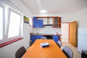 a kitchen with a wooden table in a room at Apartments Marina in Petrcane