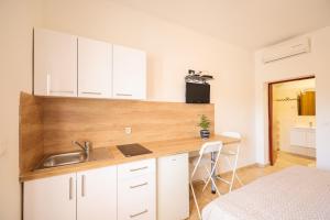 a kitchen with a sink and a desk in a room at Apartments Marina in Petrcane