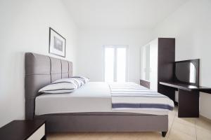 a bedroom with a large bed and a television at Apartments Marina in Petrcane