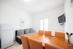 a dining room with a table and a couch at Apartments Marina in Petrcane