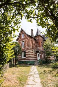 una casa de ladrillo con una chimenea encima en La Villa de l'Etoile 10 personnes, en Forges-les-Eaux
