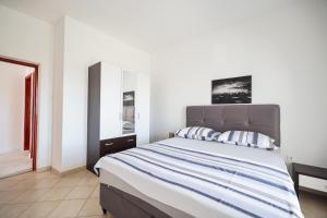 - une chambre avec un grand lit et un miroir dans l'établissement Apartments Marina, à Petrčane